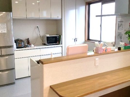 キッチンは対面式で奥には大きな窓が付き明るい雰囲気。冷蔵庫や炊飯器もある。