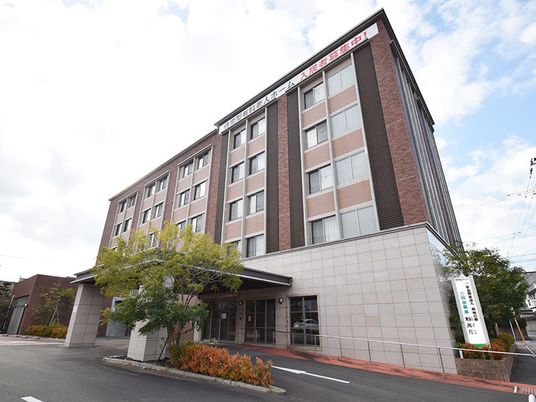 5階建てのおしゃれな外観。車寄せの幅も広く、季節の花や木も植えられている。