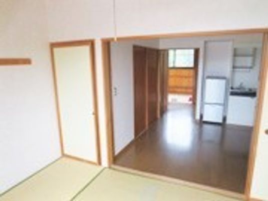 畳敷きの和室のフローリングの洋室があり、洋室にはキッチンや冷蔵庫も設置されている。