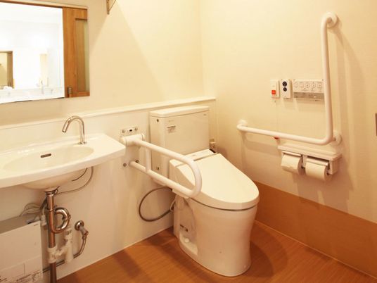 トイレは可動式の手すりやエル字型の手すりが付き、手洗い場も付いている。