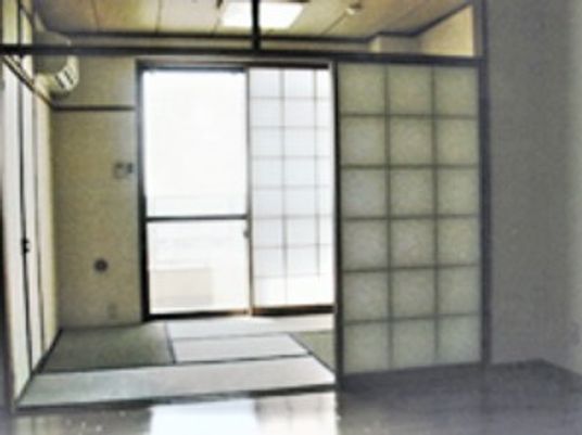 畳６畳程度の和室と手前のリビングが一体になった部屋の様子