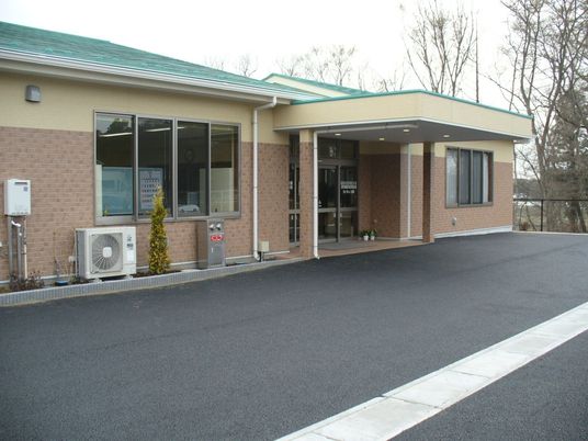 平屋建てのやわらかい色合いの建物。グループホーム菜の花の外観