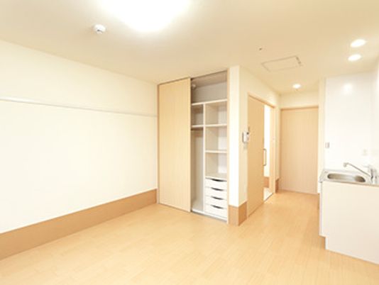 フローリングの部屋には仕切りや引き出しが付いた大型のクローゼットがあり、流しも付いている。