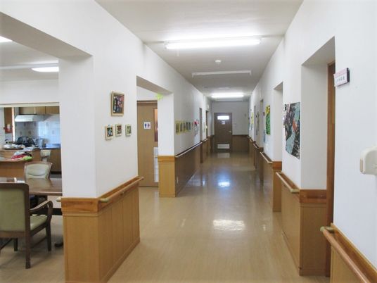 廊下の幅は広くまっすぐで、両サイドに手すり、入居者の作品も飾られている。