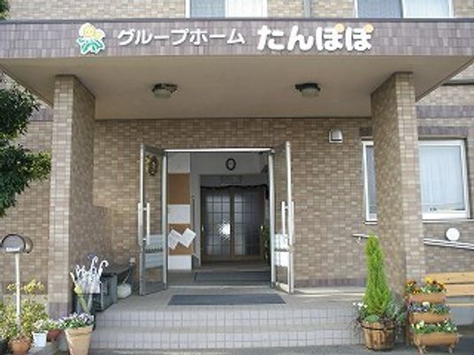 ブラウンのレンガ調の外壁が印象的な建物。大きな屋根が付いている。