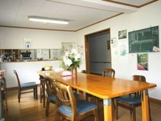 ダイニングテーブルとイスのセットが置いてある施設内の共有スペース