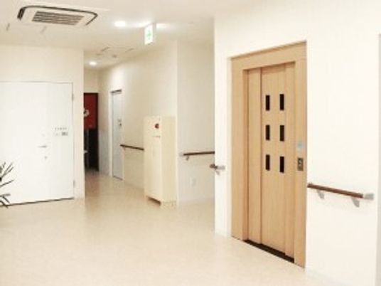 エレベーターホールの様子。手すりがついている廊下を写した写真