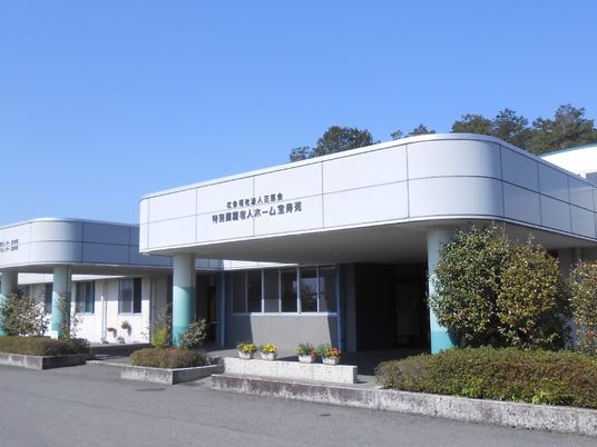 日当たりのいい場所に建っている平屋建ての建物はエル字型で玄関には車寄せが付いている。敷地内には横断歩道のような模様が描かれている。