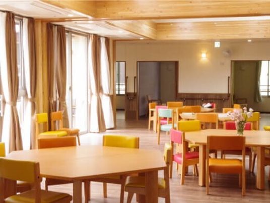 六角形の木製のダイニングテーブルセットが複数置かれた食堂には大きな窓が付いている。