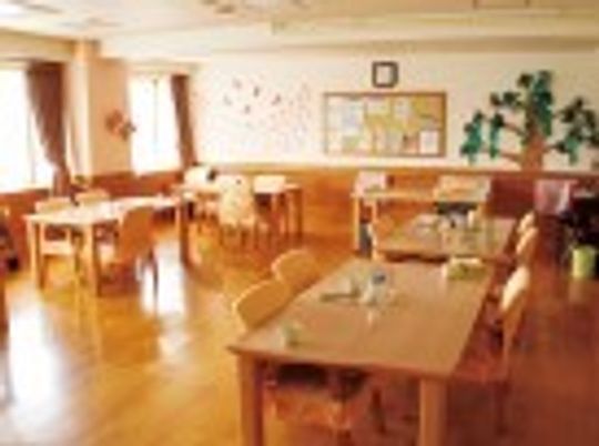 木製の家具類が並んでいる施設のリビング。家庭的な雰囲気のフローリングの部屋