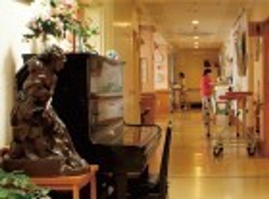 手前に観葉植物とピアノが置いてあるリラックススペース。施設内の一角
