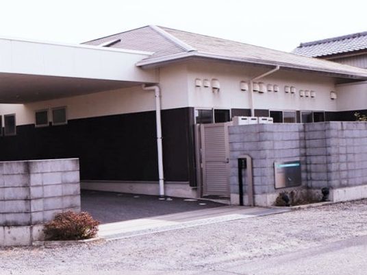外壁と小さな平屋建ての建物が移っている写真。グループホームせせらぎの外観
