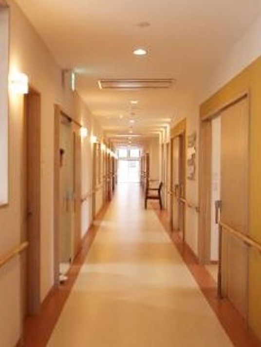 施設内の廊下を写した写真。両側に個室のドアが見えている様子