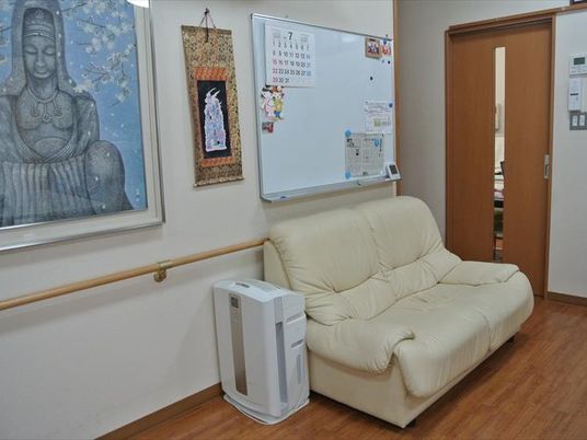 白いソファや加湿器がドアの前に置かれている廊下