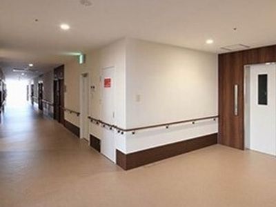 手すりがついた施設内の廊下の様子。オールバリアフリーの床と幅が広い共有スペース