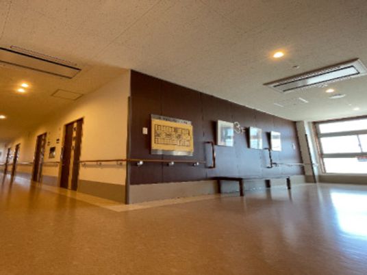 幅の広い廊下には手すりが設置され、ホールには大きな窓が付き、壁際にはベンチも設置されている。