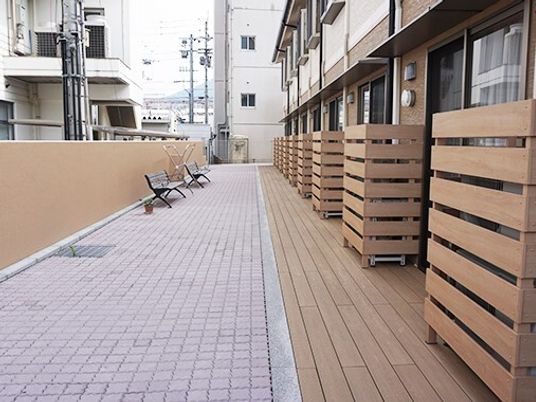 ２台のベンチが置かれたテラスに余計なものはなく、周りには背の高い建物がある。