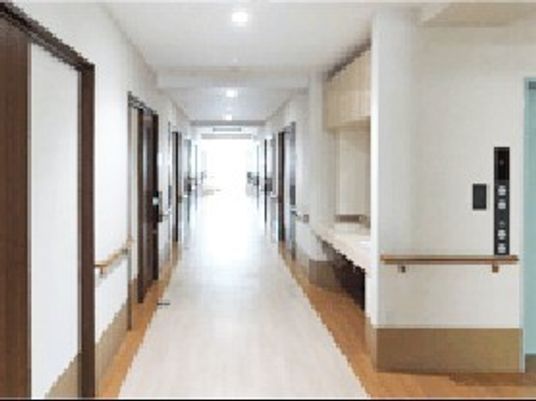 両サイドに手すりがあるまっすぐな廊下には居室のドアが並び、突き当りには大きな窓があり明るい。