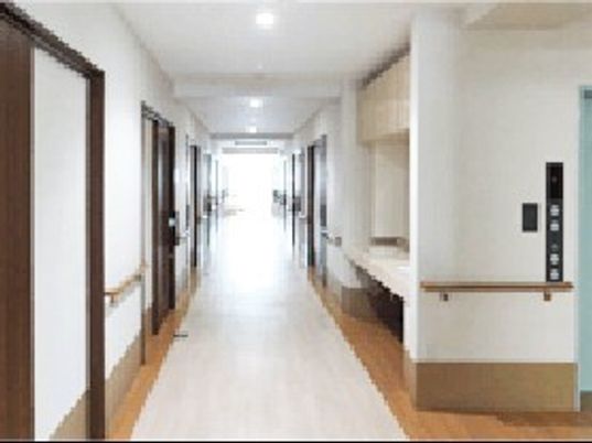 両サイドに手すりがあるまっすぐな廊下には居室のドアが並び、突き当りには大きな窓があり明るい。
