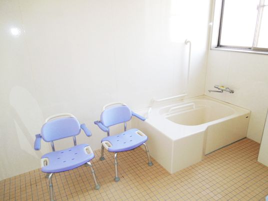 清潔感のある高齢者用浴室。座った姿勢で入るためのシャワーチェアが置いてある