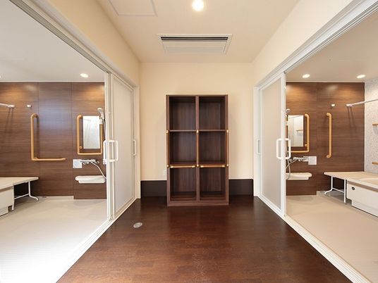 脱衣所に両側に浴槽が置いてある浴室の様子。施設の水回り設備