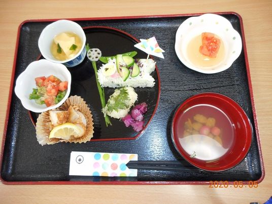 こいのぼりのカタチのおにぎりや小さな器に盛られたおかずが複数あり、汁物やデザートもある。