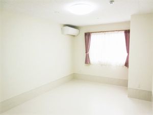 奥のほうに窓がある広めの個室の様子。エアコンとカーテンがかかった窓が移っている写真