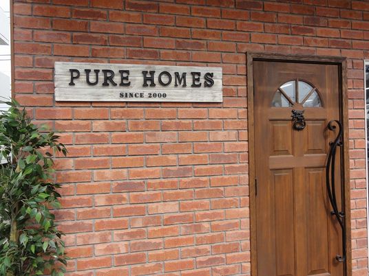 日当たりのいい芝生の上で穏やかな表情で語り合っている高齢の夫婦と若い女性の様子。