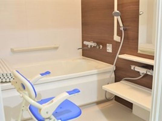 一人用の浴槽が置かれた浴室には、手すりやシャワーチェア、シャワーも設置されている。