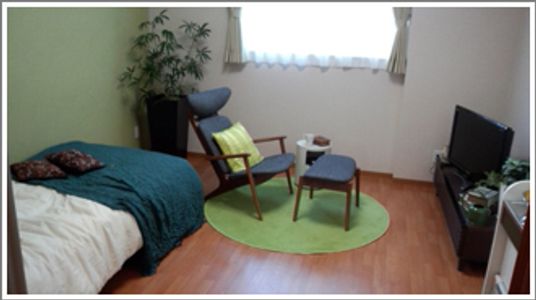 モダンなデザインの家具がならぶ小さな部屋。ベッドと感じの良い家具類が並んでいる様子