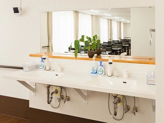 洗面台が二つ並んでいる施設内の共有スペース。フットレス設計の洗面台