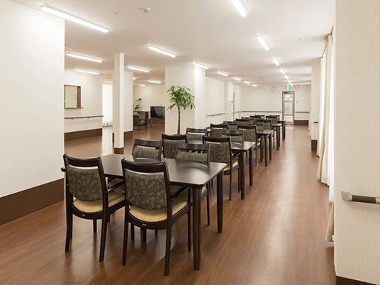 四人掛けのテーブルと椅子がいくつも並んでいるリビングスペースの様子