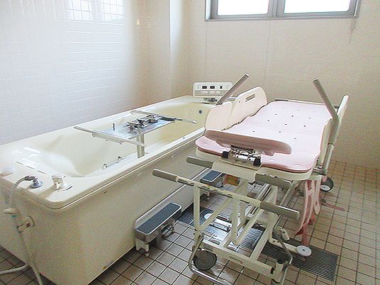 寝たまま入浴できる寝台浴が設置された浴室には大きな窓があり、明るい雰囲気。