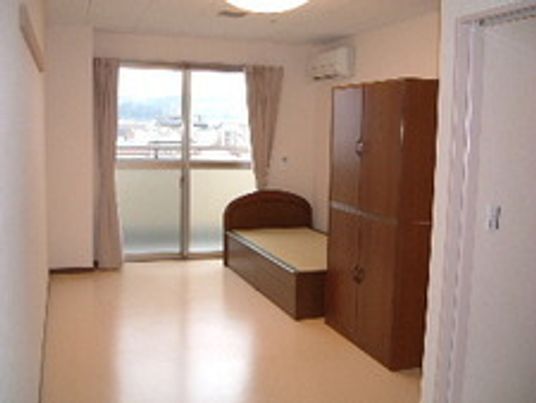 日当たりが良さそうな窓のあるきれいな部屋。大きめの収納、タンスがあるのが見えている
