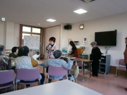 娯楽室で仲間と一緒にイベントを楽しんでいる高齢者。スタッフの姿も見えている