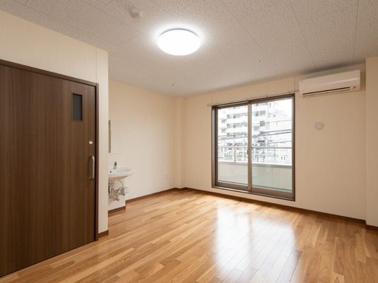 エアコンとトイレ、洗面台がついている施設内の居室。入居前の部屋の様子
