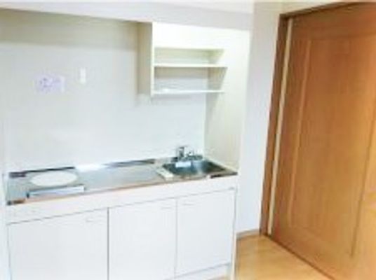 小さなミニキッチンがついた部屋の様子。右側に収納設備のようなドアがある