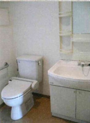 白でまとめられたトイレと洗面スペース。トイレの横の壁には手するもある。