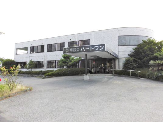 鉄骨造２階建ての建物の外観写真。駐車場スペースがある広めの敷地内の場所