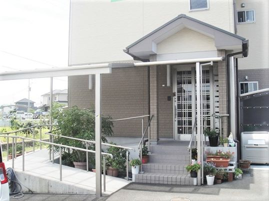 車いす用のスロープ付きエントランスの様子。階段がありその向こうに出入り口がある
