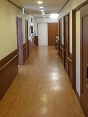 まっすぐな廊下には両サイドに手すりと居室のドアが付き、通行の邪魔になるものは置かれていない。