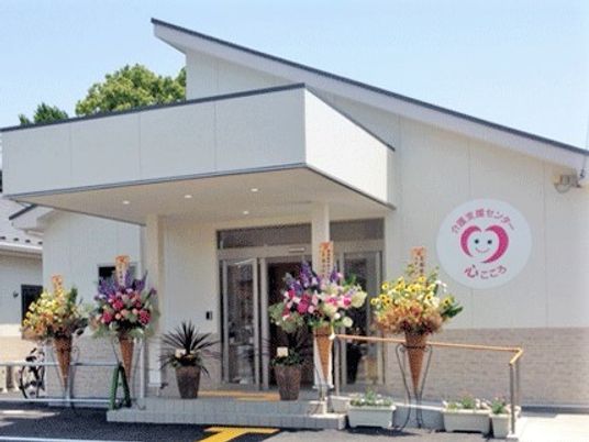 白を基調にした平屋建ての建物。玄関周りには階段とスロープが設置されている。