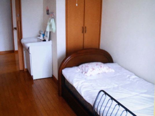 介護用ベッドと洗面台、収納設備など生活用品と設備がそろっている施設内の一室