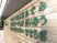 看板。文字色は緑、壁は薄茶のレンガ