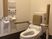 背もたれや手すりが設置されたトイレの壁にはカラフルな操作パネルが付いている。