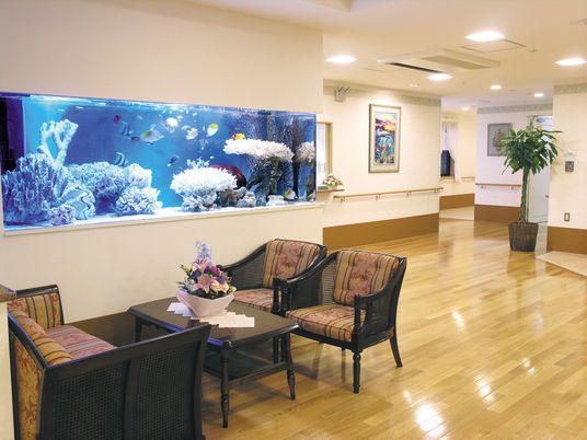 水槽が埋め込まれた壁のそばには応接セットが置かれ、館内には全域に手すりが設置されている。