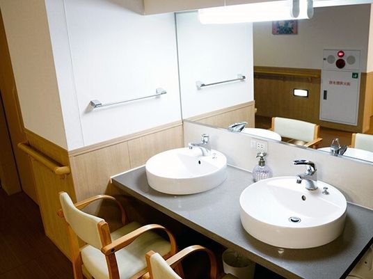 座ったまま利用できるフットレスの洗面台。椅子が置いてある様子