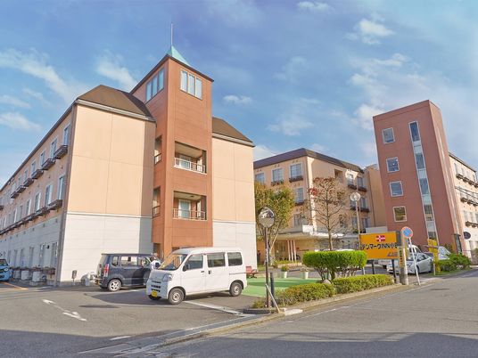 やわらかい色合いの建物の外観写真。鉄骨造の大きめの建物の外観