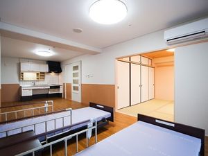 ベッドが2台置かれたフローリングの部屋の奥にはキッチンがあり、畳敷きの和室もある。