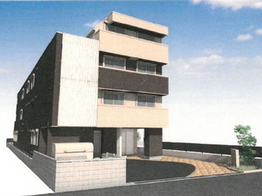 4階建ての建物はブラウン系でまとめられ、屋外には駐車スペースが設置されている。